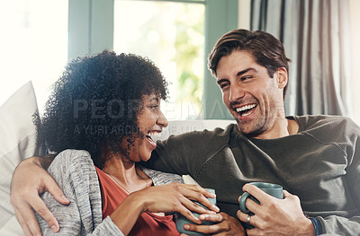 Buy stock photo Shot of an affectionate young couple drinking coffee and spending quality time together at home
