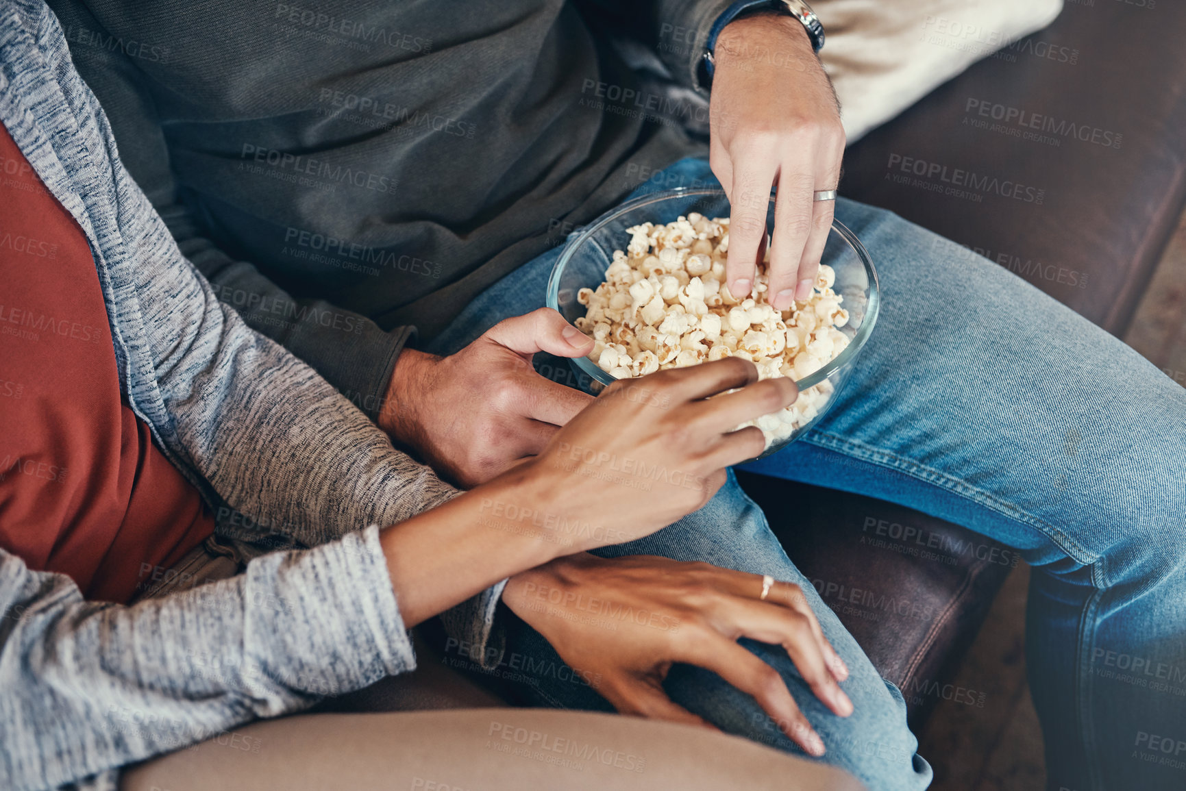 Buy stock photo Couple, hands and eating popcorn together in home, couch and bowl of snacks in living room. People, love and bonding on organic food or meal for support, watching tv and streaming movies on sofa