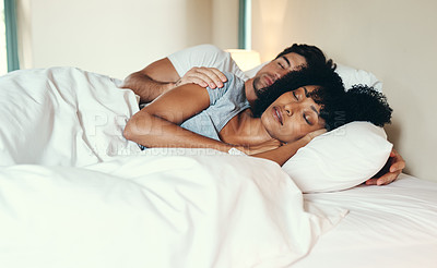 Buy stock photo Shot of an affectionate young couple sleeping peacefully together in their bed at home