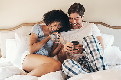 Buy stock photo Shot of an affectionate young couple drinking coffee and spending time together in bed at home