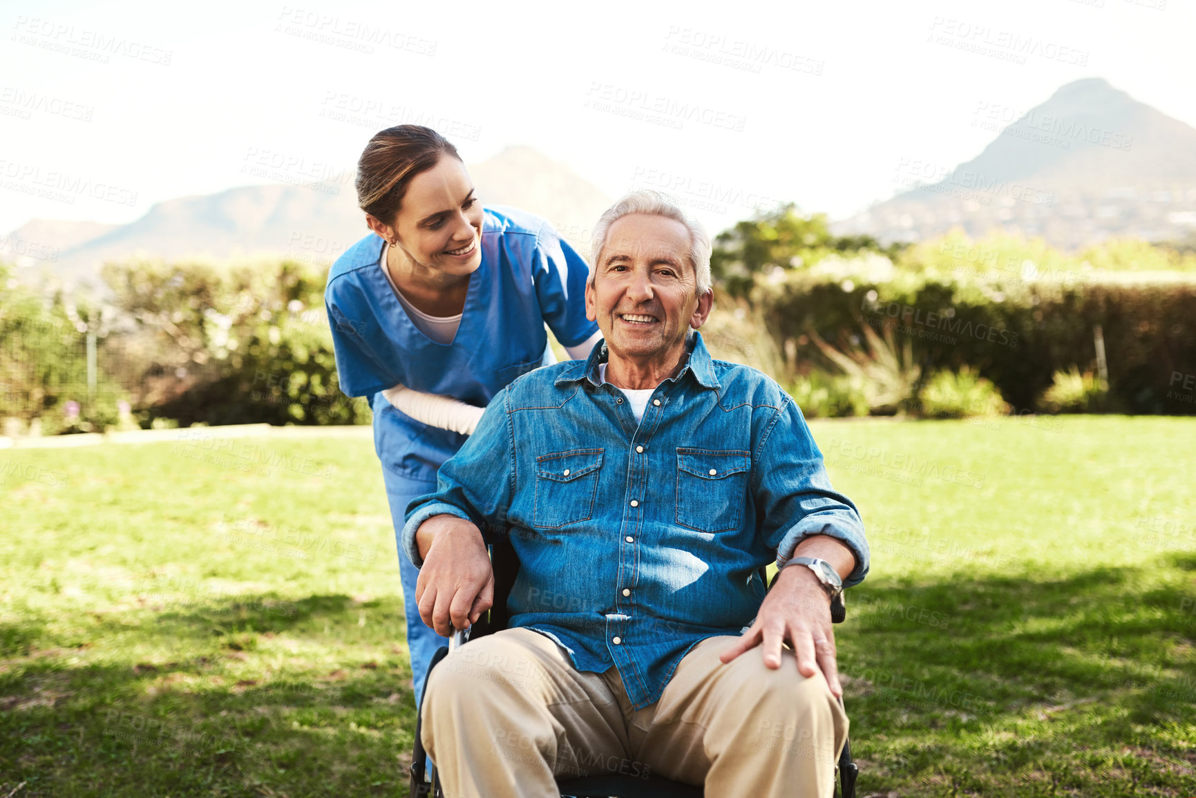 Buy stock photo Cropped shot of a young female nurse outside with a senior patient in a wheelchair