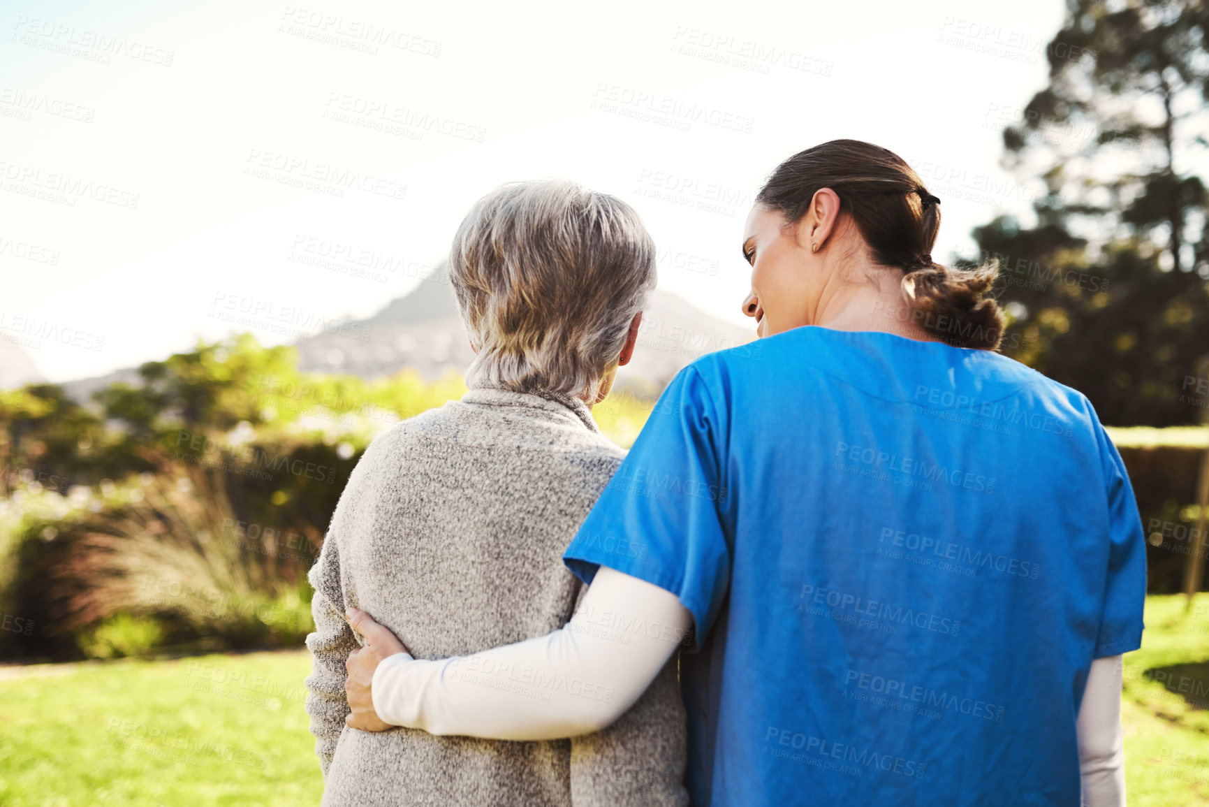 Buy stock photo Senior woman, nurse and hug in elderly care, life insurance or support together in nature. Rear view of mature female with caregiver in healthcare, medical aid or garden walk at nursing home outdoors
