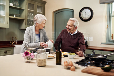 Buy stock photo Shot of an affectionate senior couple having a meal together in the kitchen at home