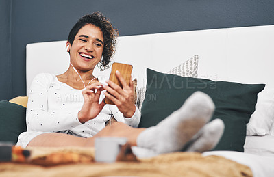 Buy stock photo Full length shot of an attractive young woman sitting on her bed and using her cellphone while at home