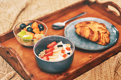 Buy stock photo Cropped shot of a neatly laid out breakfast arranged on a wooden tray and served in bed at home
