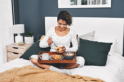 Buy stock photo Full length shot of an attractive young woman enjoying breakfast in bed while at home