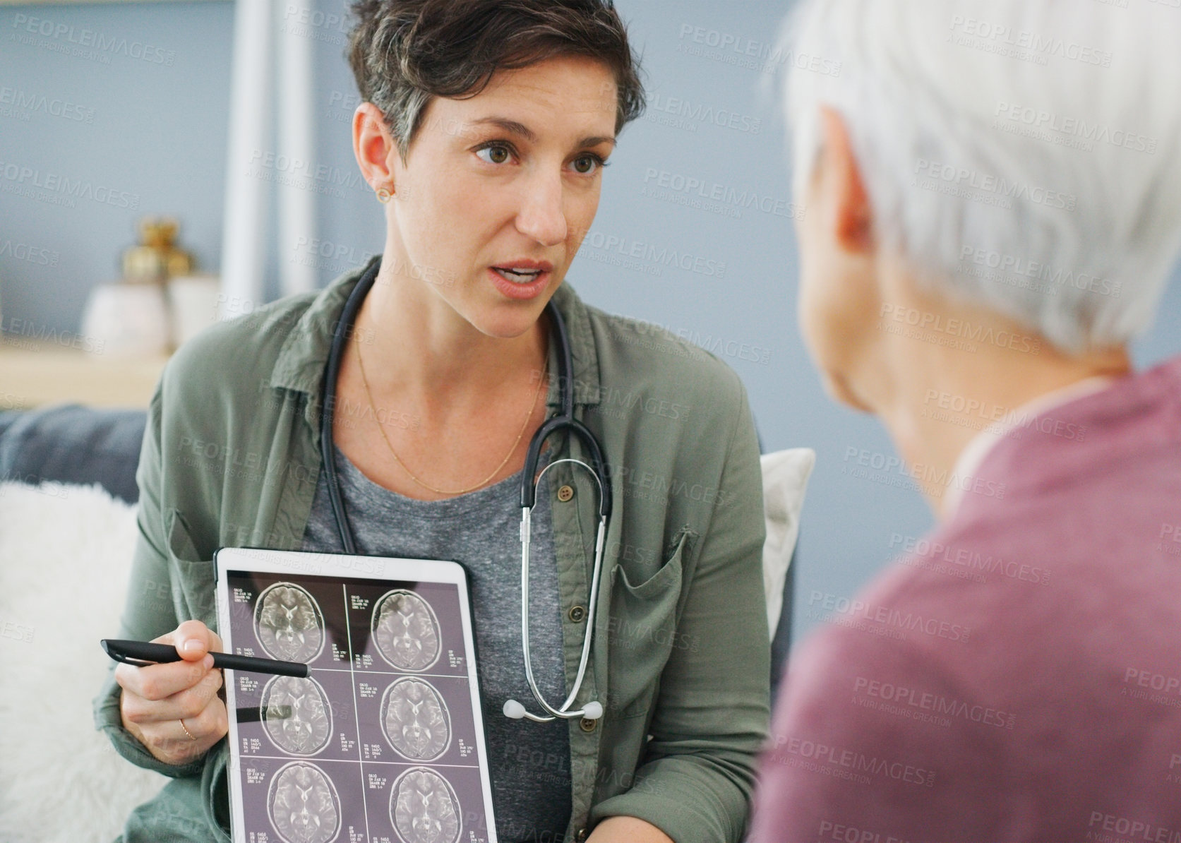 Buy stock photo Cropped shot of an attractive young woman showing a senior patient her medical results on a tablet while sitting down