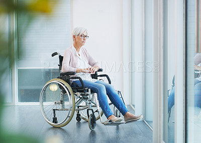 Buy stock photo Full length shot of a contemplative senior woman sitting in a wheelchair while looking away in a nursing home