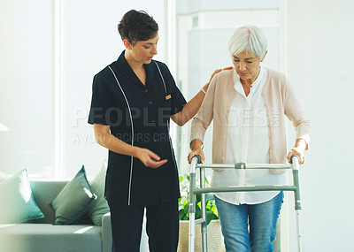 Buy stock photo Cropped shot of an attractive young healthcare professional helping her senior patient walk with a walker in a nursing home