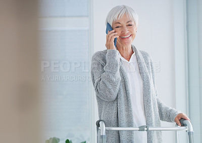 Buy stock photo Cropped shot of a happy senior woman standing with her walker while talking on her cellphone in the nursing home