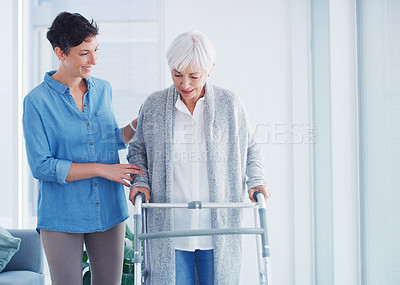 Buy stock photo Cropped shot of an attractive young woman helping her senior mother walk with her walker in a nursing home