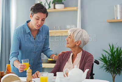 Buy stock photo Cropped shot of a happy senior woman sitting and having breakfast with her attractive young daughter while at home