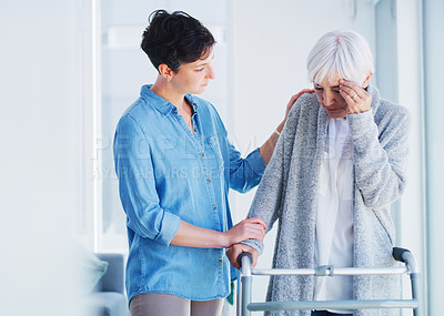 Buy stock photo Cropped shot of an affectionate young woman helping her senior mother who is suffering from a headache while at home