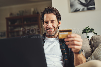 Buy stock photo Man, home and smile on laptop with credit card on sofa for online shopping, payment and saving plan. Rewards, happy and couch in living room for internet banking, budget and investment or finance