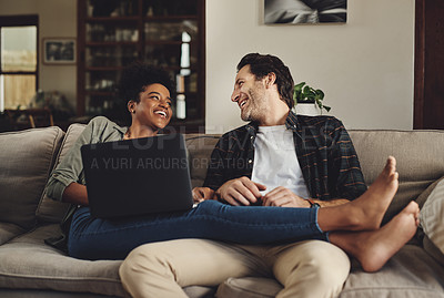 Buy stock photo Full length shot of a happy young couple using a laptop while relaxing on a couch home