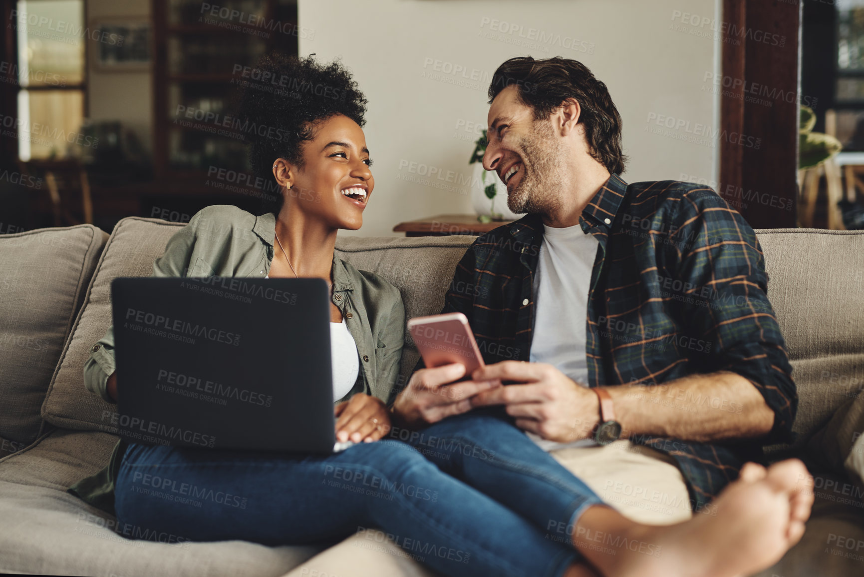 Buy stock photo Couple, relax and smile with technology on sofa for social media, streaming subscription and online shopping for apartment. Man, woman and together in home with laptop or smartphone for connectivity.