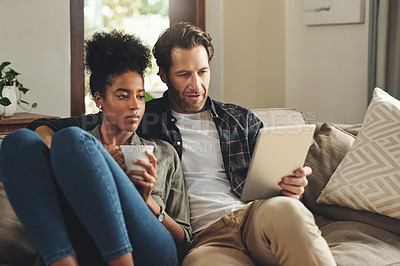 Buy stock photo Love, home and couple with a tablet, connection and social media for communication, romance and relax. Partners, man and woman on a couch, interracial and technology for chatting, texting and bonding
