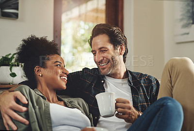 Buy stock photo Shot of a happy young couple drinking coffee and spending some quality time together at home