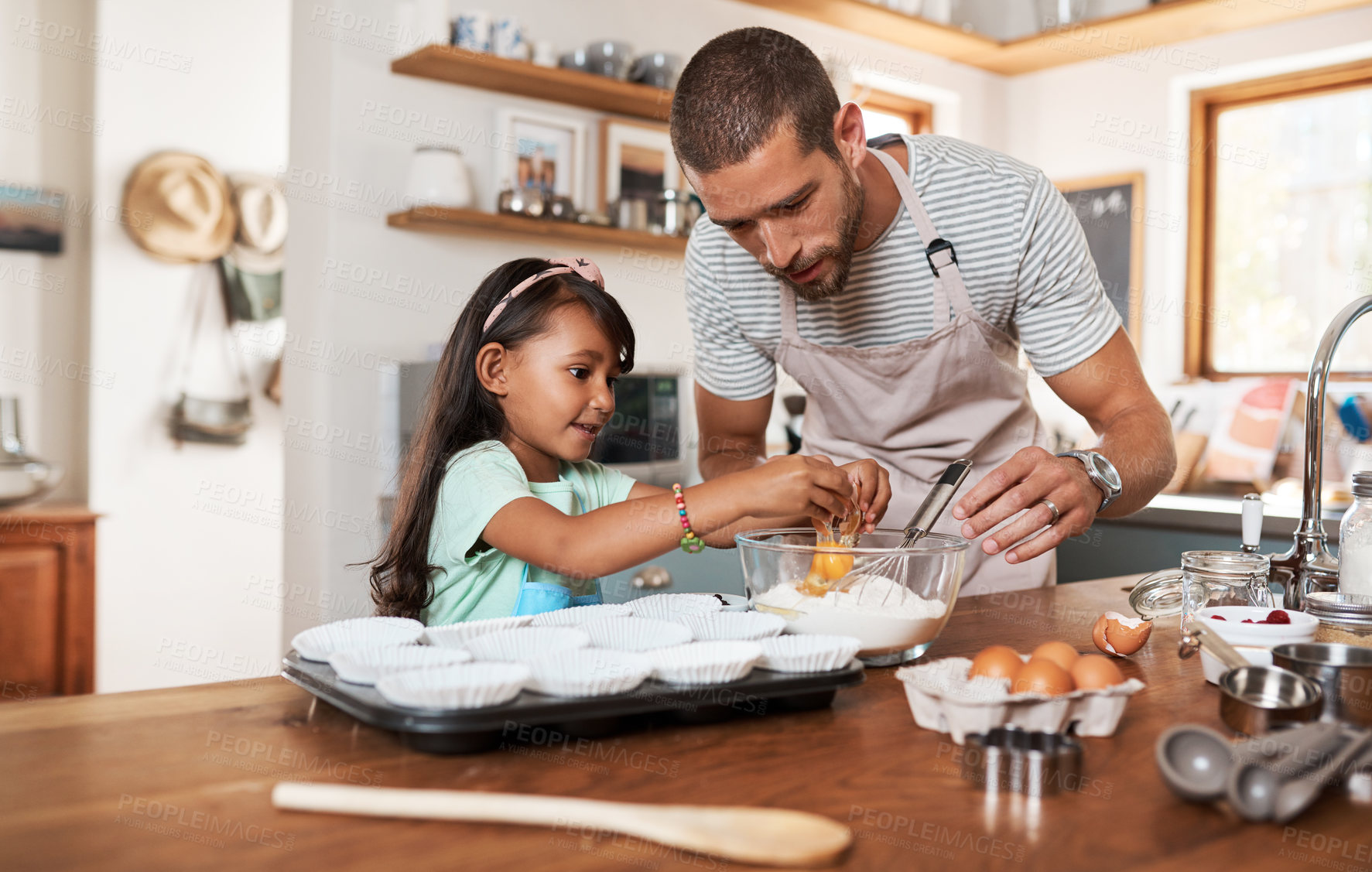 Buy stock photo Cropped shot of a young man baking at home with his young daughter