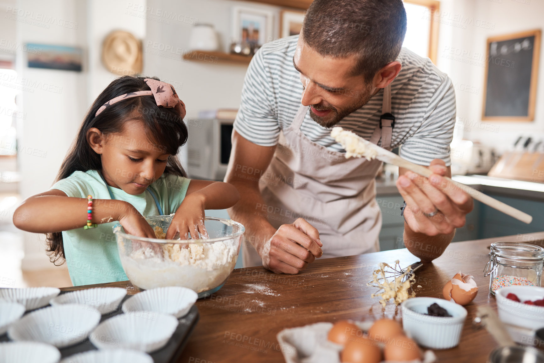 Buy stock photo Cropped shot of a young man baking at home with his young daughter