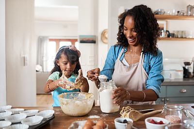 Buy stock photo Shot of a woman baking at home with her young daughter