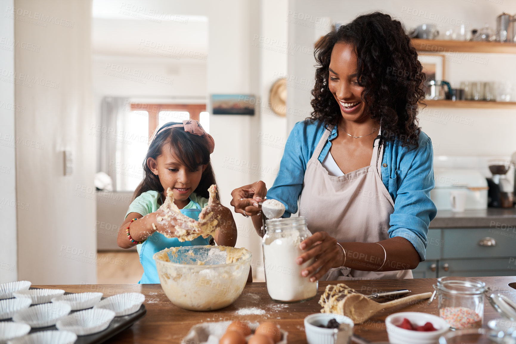 Buy stock photo Shot of a woman baking at home with her young daughter