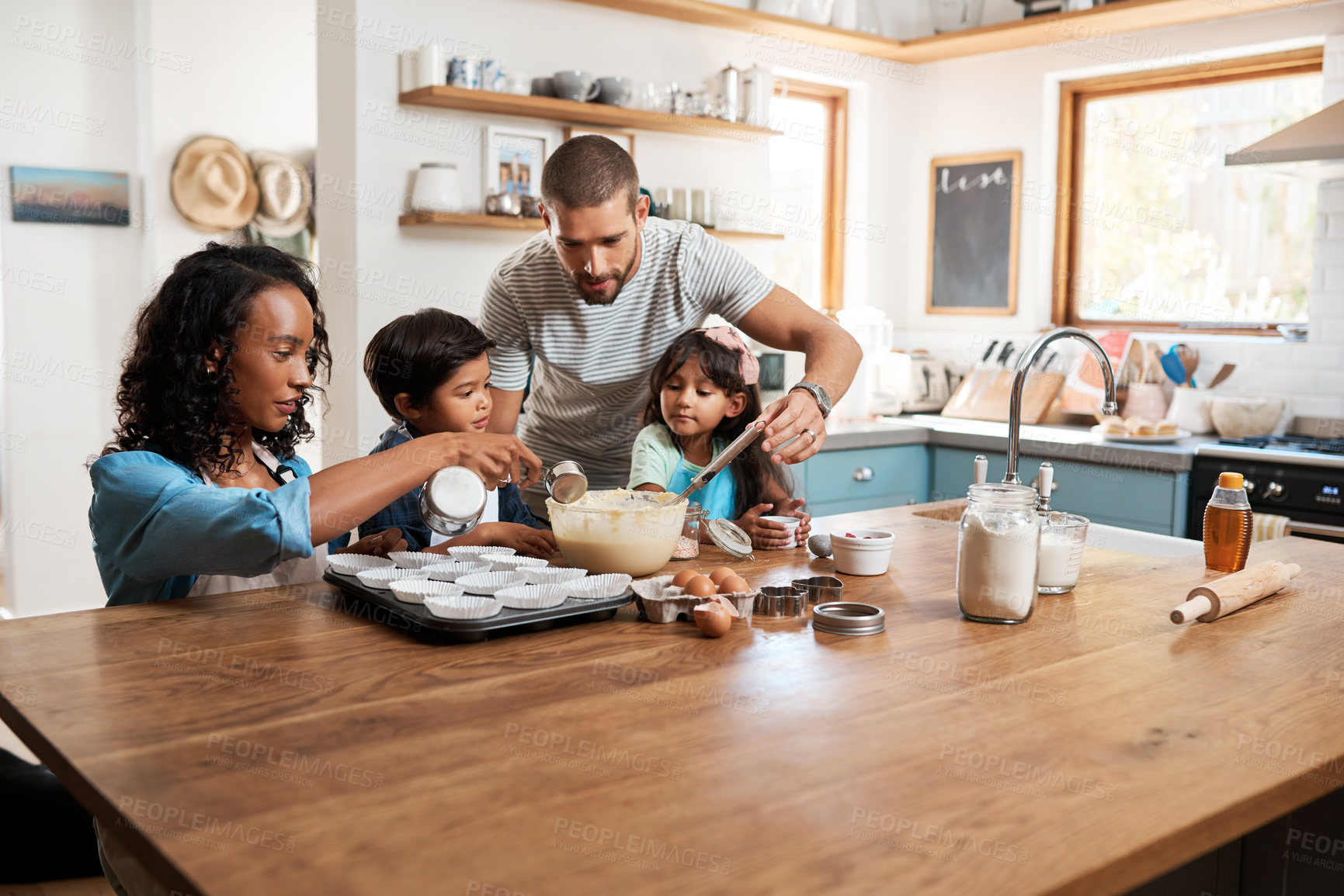 Buy stock photo Cropped shot of a young couple baking at home with their two children