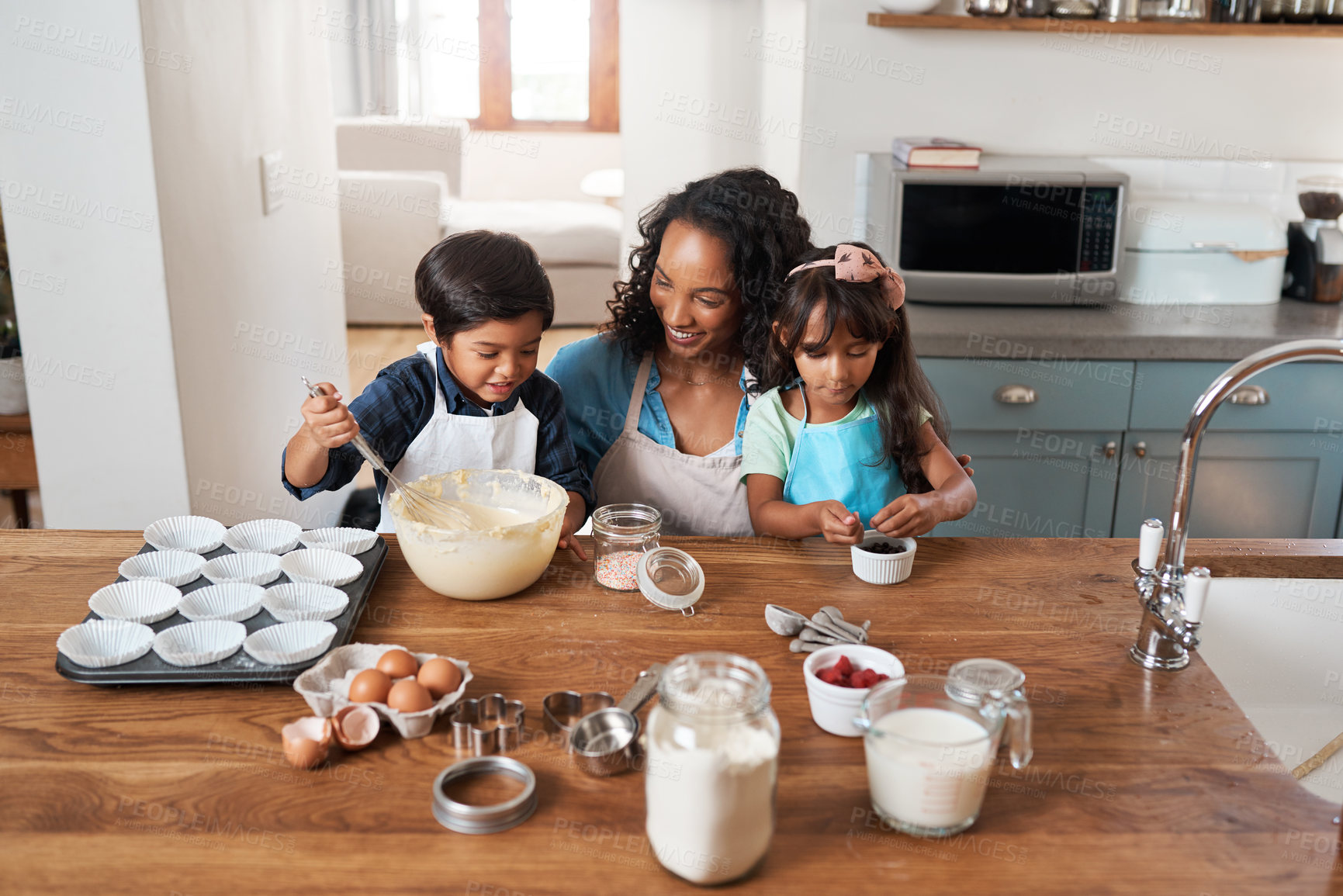 Buy stock photo Shot of a young woman baking with her two children