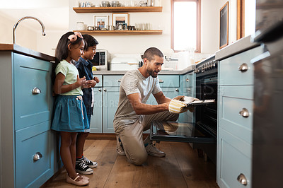 Buy stock photo Shot of a young man baking at home with his two young kids