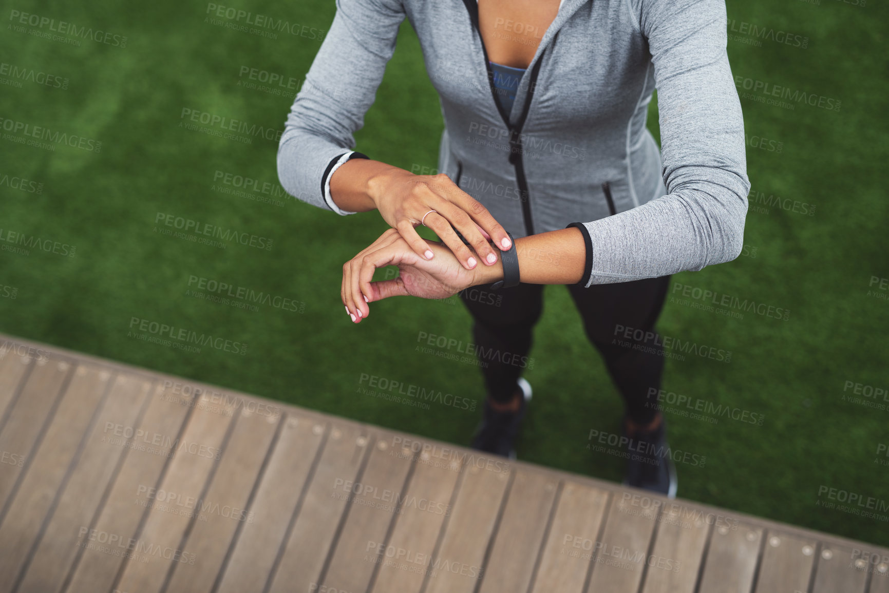 Buy stock photo High angle shot of a sporty young woman checking her watch while exercising outdoors
