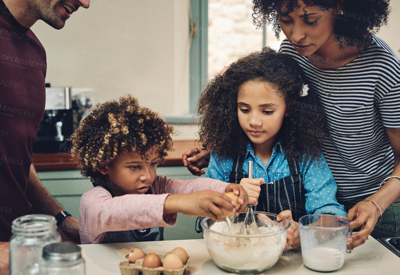 Buy stock photo Cropped shot of a young couple baking at home with their two children