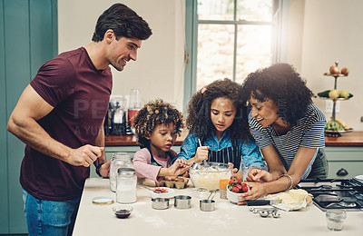 Buy stock photo Cropped shot of a young couple baking at home with their two children