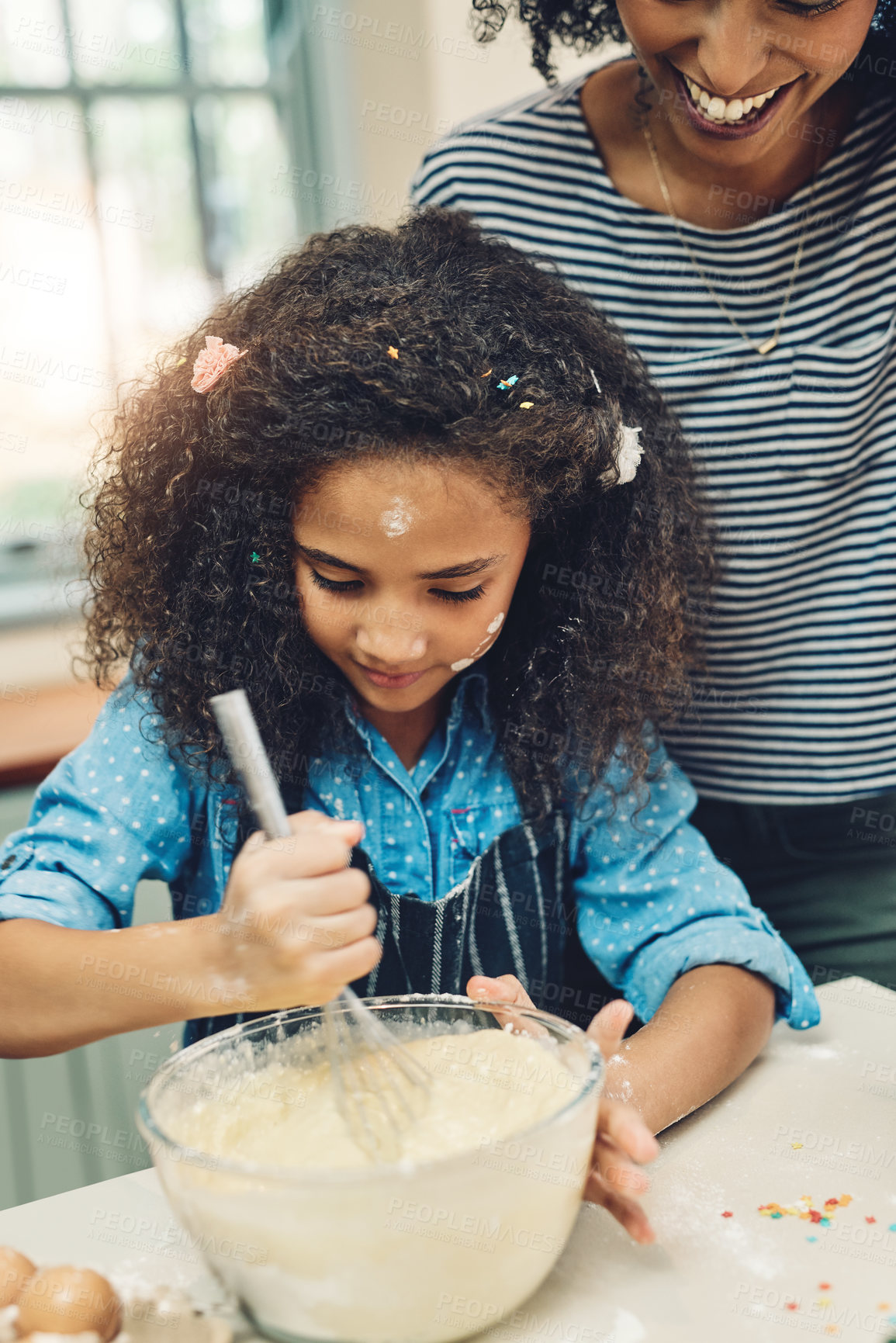 Buy stock photo Shot of a little girl baking at home with her mother's help