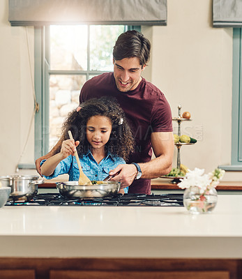 Buy stock photo Shot of a young girl cooking at home with the help of her father