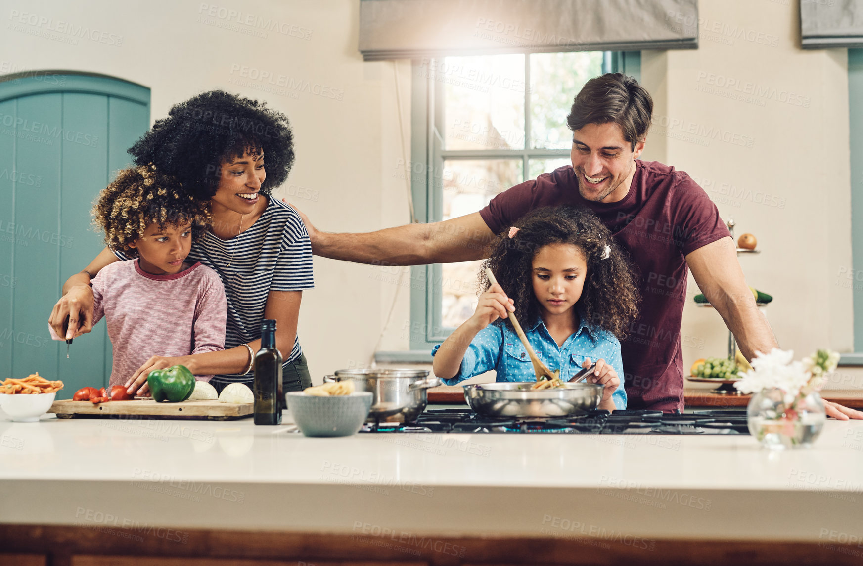 Buy stock photo Shot of a family of four cooking together in their kitchen at home