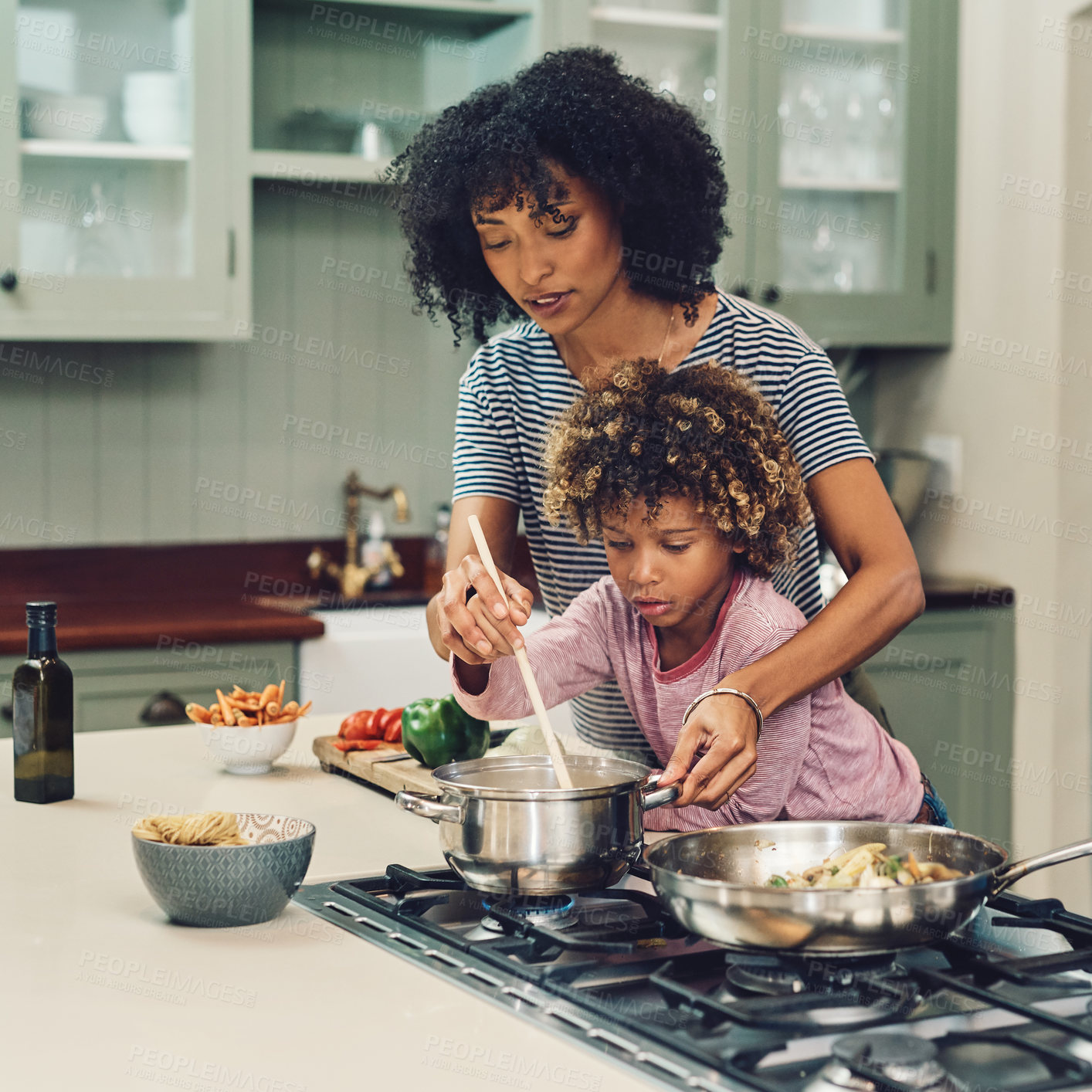 Buy stock photo Cropped shot of a young boy cooking with his mother in the kitchen at home