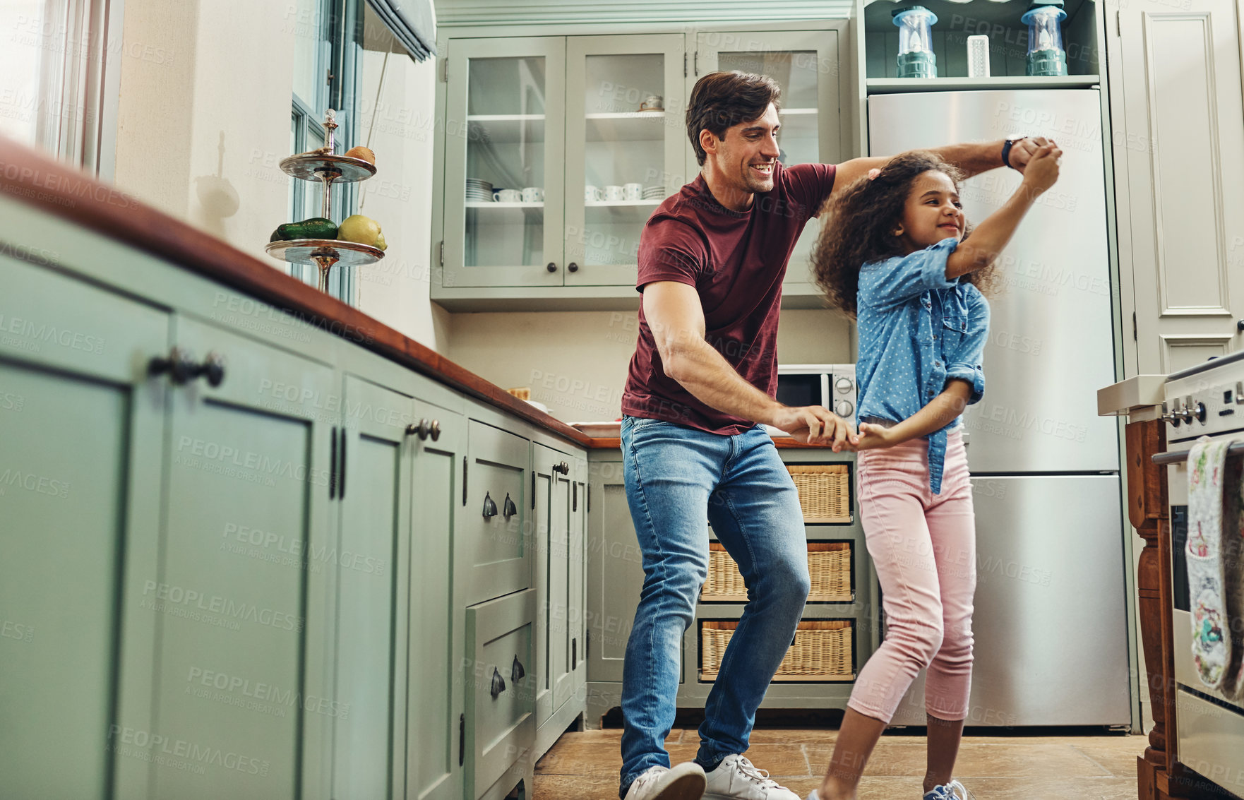 Buy stock photo Shot of a young man dancing with his daughter in the kitchen at home