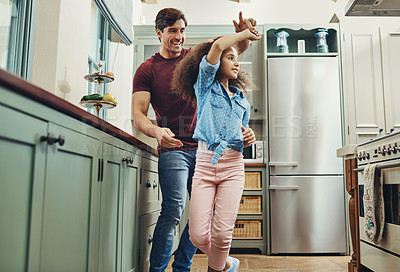 Buy stock photo Shot of a young man dancing with his daughter in the kitchen at home