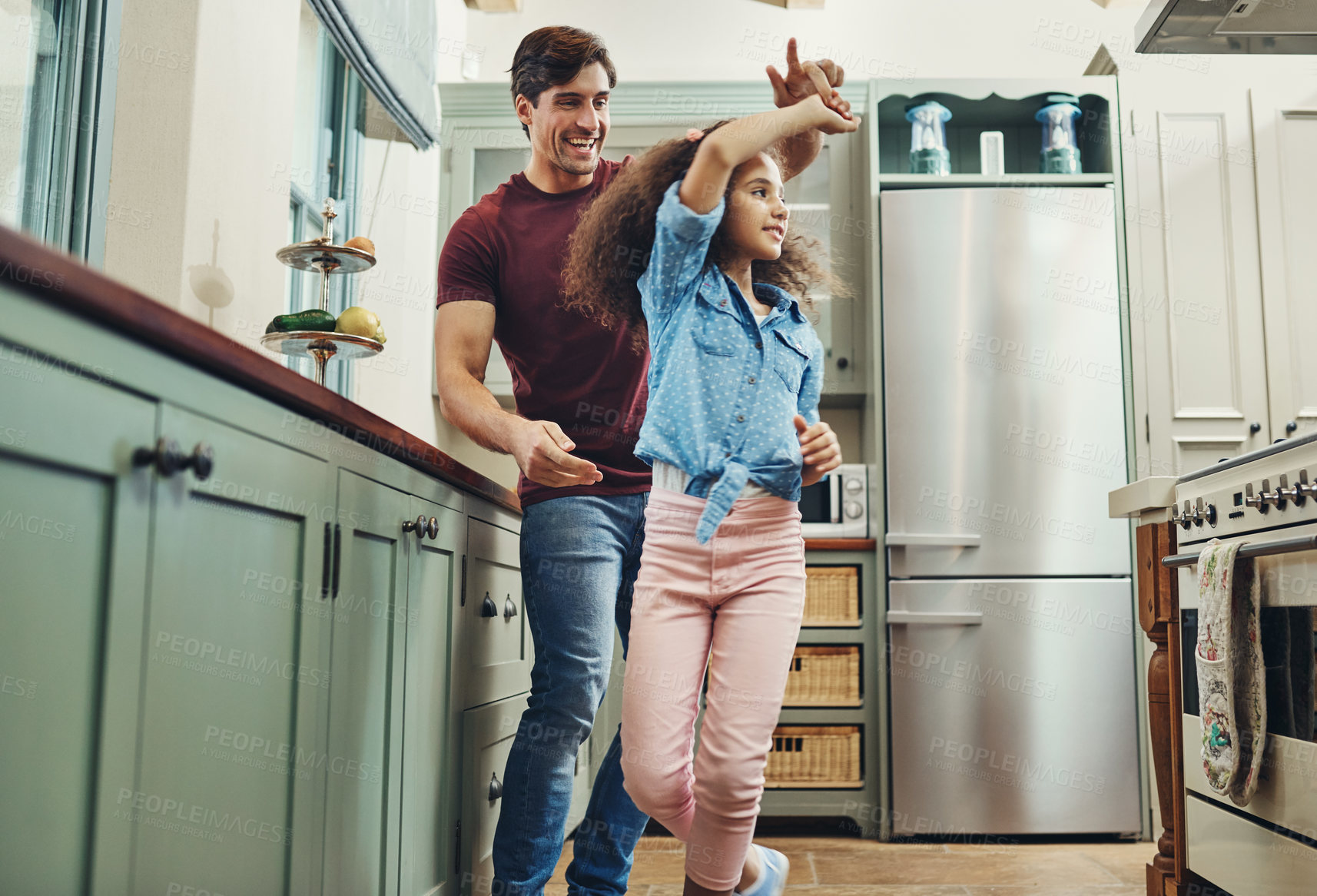 Buy stock photo Shot of a young man dancing with his daughter in the kitchen at home