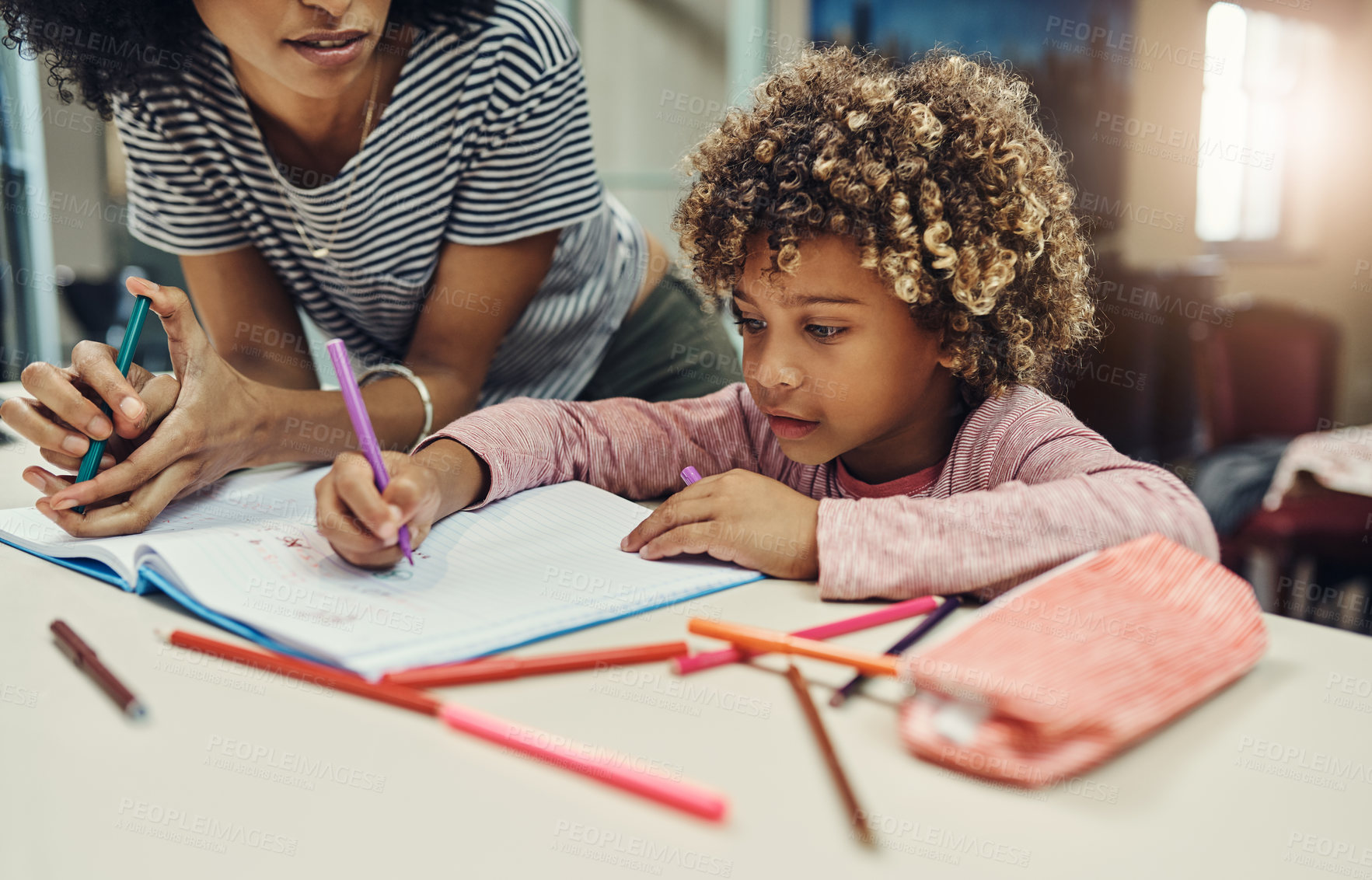 Buy stock photo Cropped shot of a woman helping her son with his homework at home