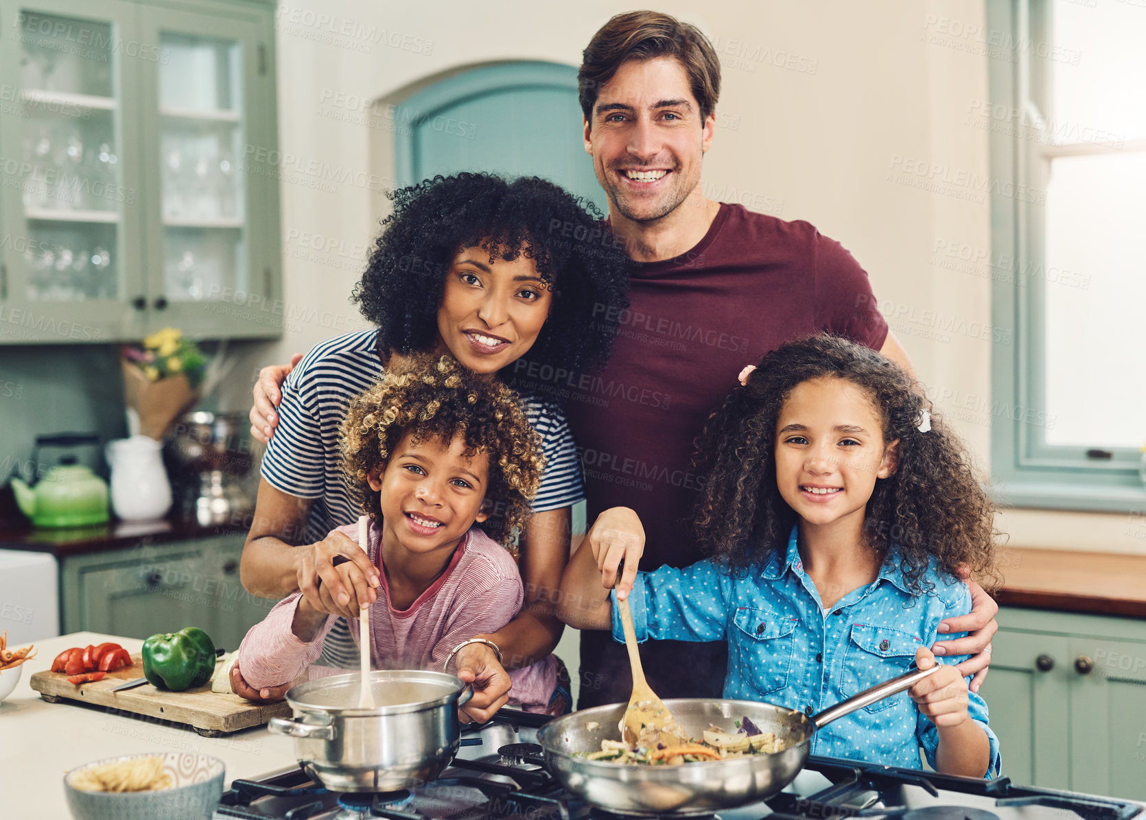 Buy stock photo Shot of a family of four cooking together in their kitchen at home