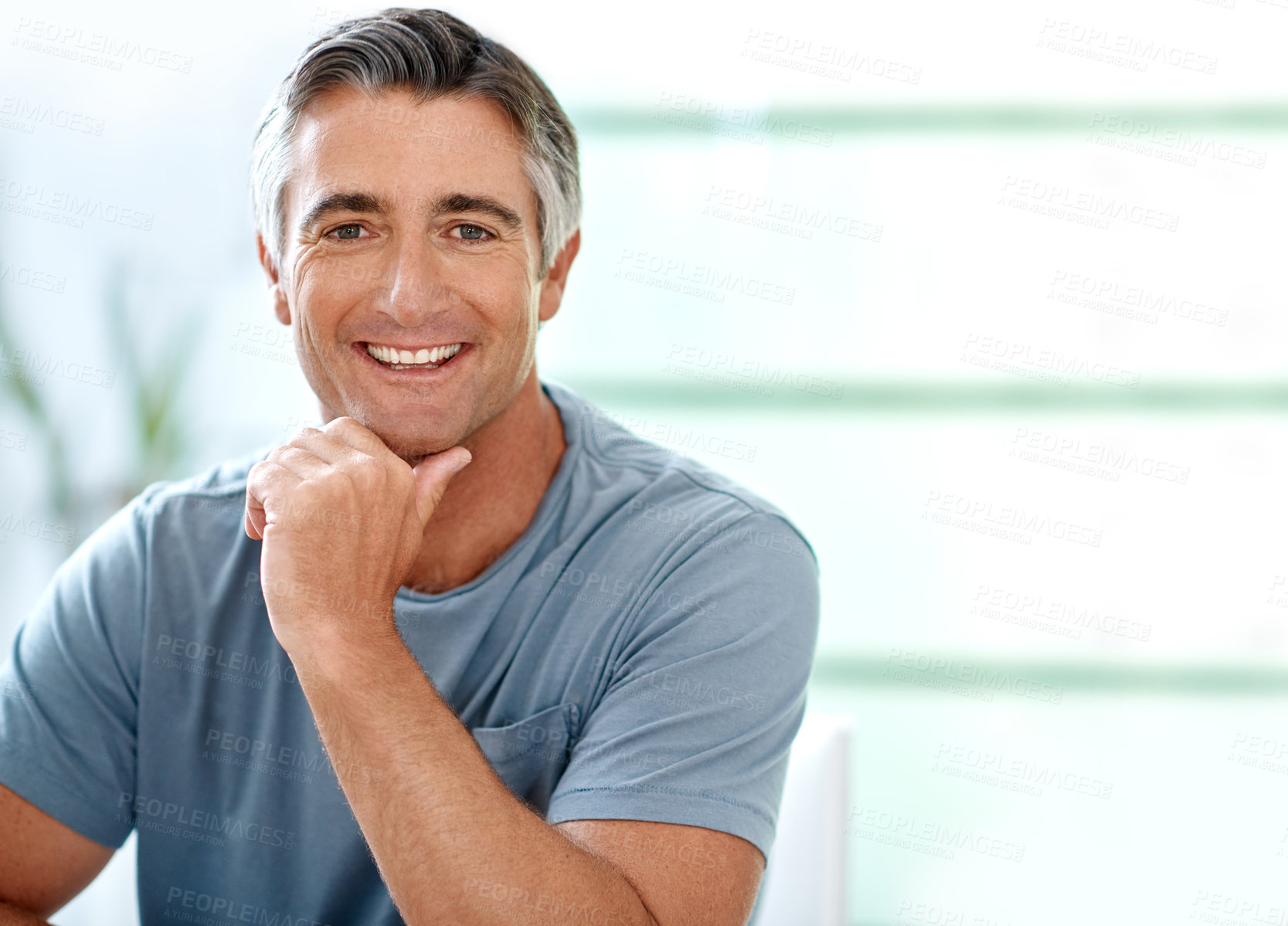 Buy stock photo Cropped portrait of a handsome mature man sitting and posing while inside his house during the day