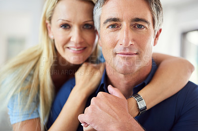 Buy stock photo Cropped portrait of a happy mature couple hugging each other while in the living room during the day