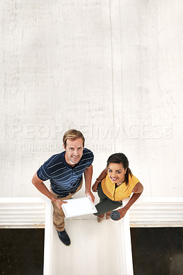 Buy stock photo High angle portrait of two business colleagues standing together on a flight of stairs in the office