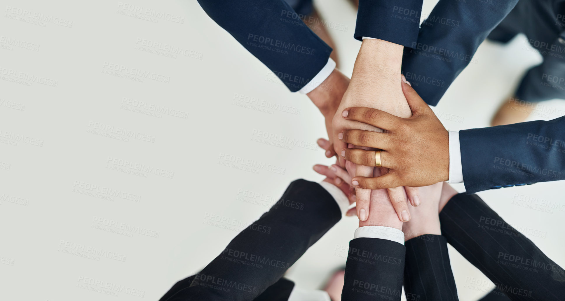 Buy stock photo High angle shot of a group of unrecognizable businesspeople standing in a huddle with their hands stacked together