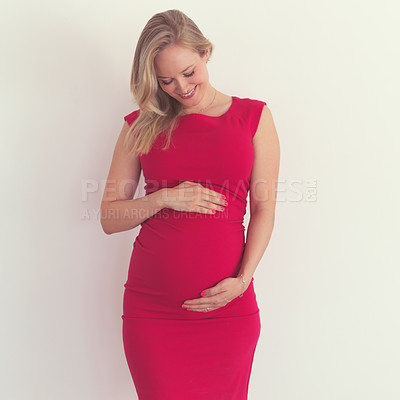 Buy stock photo Cropped shot of an attractive young woman holding her belly while standing in her home