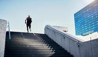 Buy stock photo Rearview shot of a young man running up stairs in the city