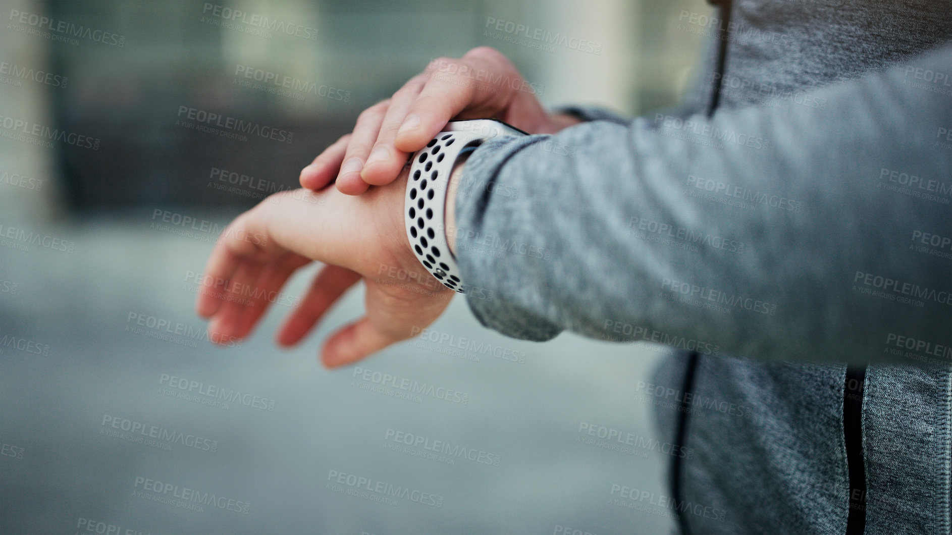 Buy stock photo Cropped shot of an unrecognizable man looking at his watch while exercising in the city