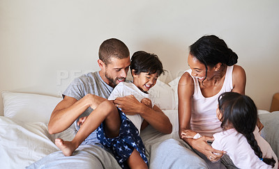 Buy stock photo Shot of a beautiful young family of four bonding and spending time together in bed at home