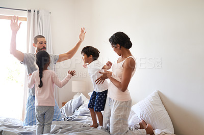 Buy stock photo Shot of a beautiful young family of four having fun and spending time together in their bedroom at home